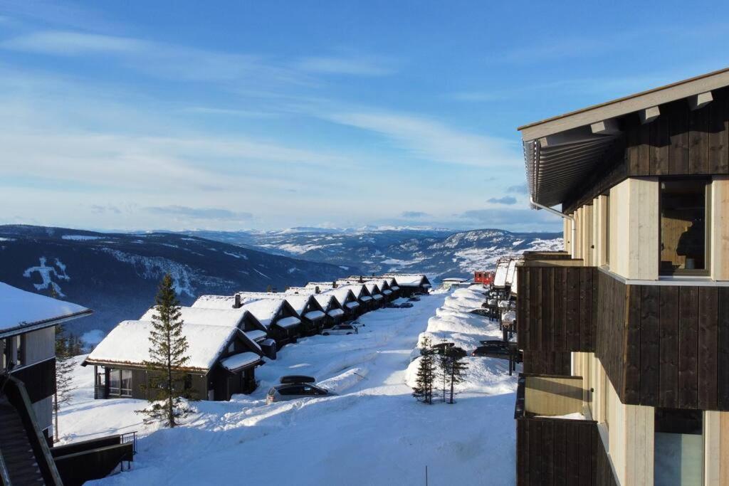 - une vue sur une rue enneigée avec des bâtiments dans l'établissement Hafjell - Penthouse - ski in/out, à Hafjell