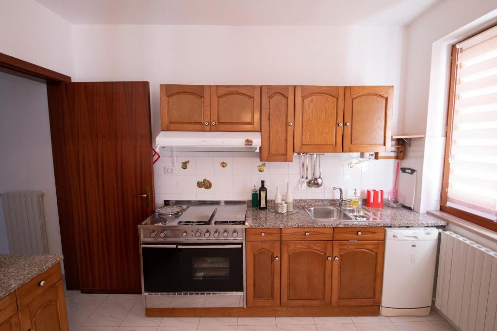a kitchen with wooden cabinets and a stove top oven at La Casa del Re - Apartments Buccino in Buccino