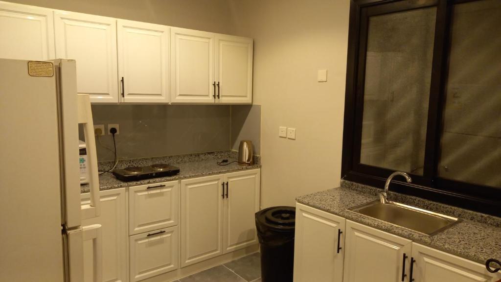 a kitchen with white cabinets and a sink at شقق بيت الوهد للشقق المخدومة in Riyadh