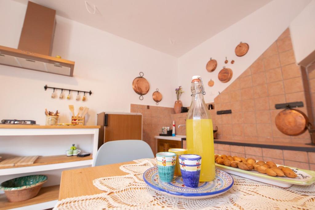 einen Tisch mit einer Flasche Saft und einem Teller Essen in der Unterkunft La Casetta - Apartments Buccino in Buccino