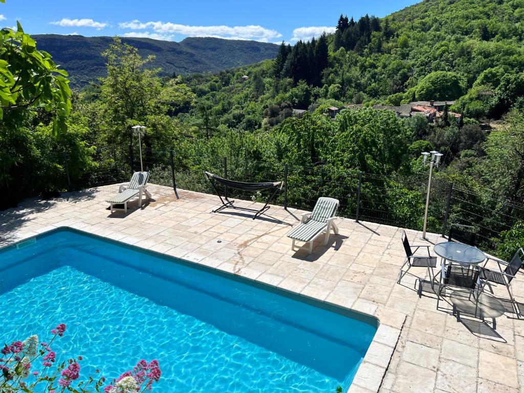 una piscina con 2 sillas y una mesa en La Roseraie - Gite avec piscine en Cévennes, en Roquedur