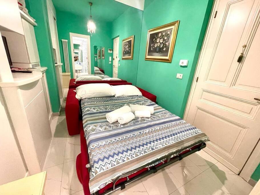2 Betten in einem Zimmer mit grünen Wänden in der Unterkunft Suite Oster Room - Ospedaletti in Ospedaletti