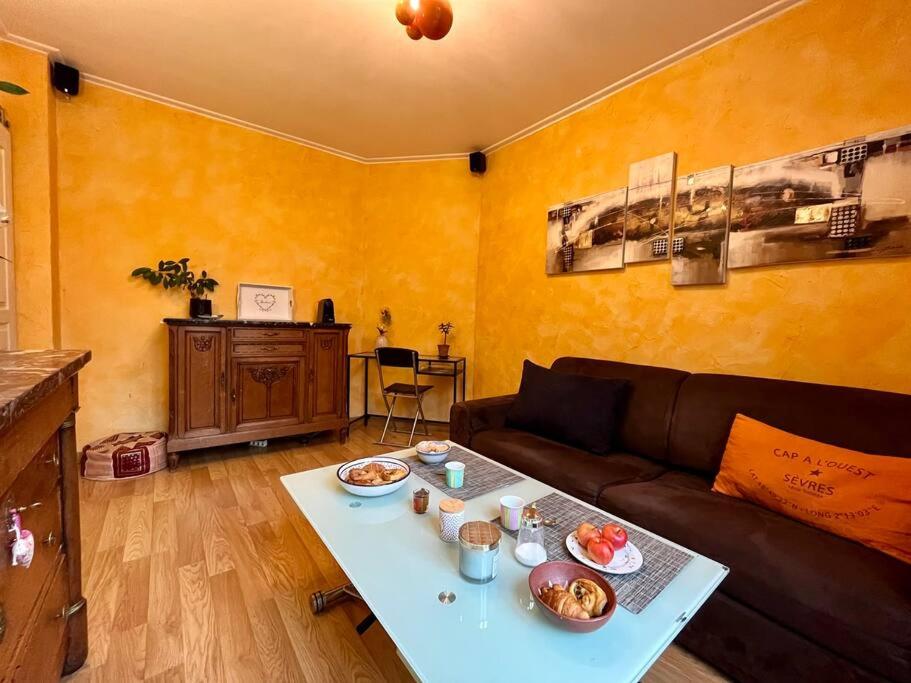 ein Wohnzimmer mit Sofa und Tisch mit Essen drauf in der Unterkunft L'interlude in Chaville