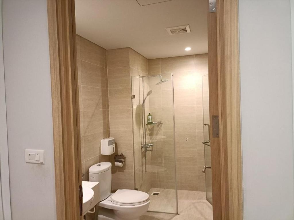 W łazience znajduje się toaleta i przeszklony prysznic. w obiekcie Kim's Apartment - 800m to Marina Beach - Full kitchen, Washing Machine w Ha Long