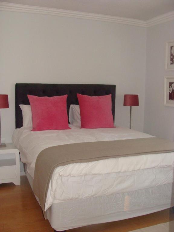 - une chambre avec un grand lit et des oreillers roses dans l'établissement Lonehill - Standard 2 Guest Suite - Suite 1B, à Sandton