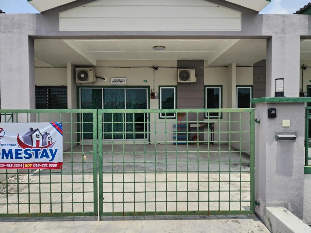 une porte avec un panneau devant un bâtiment dans l'établissement Lekir baiduri homestay, à Sitiawan