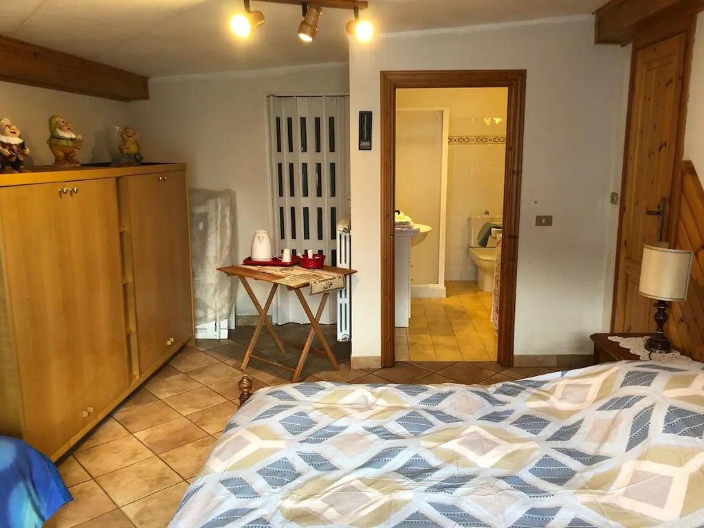 een slaapkamer met een bed en een tafel en een badkamer bij Stanza privata a 10 minuti dall'Abetone in Pian di Novello