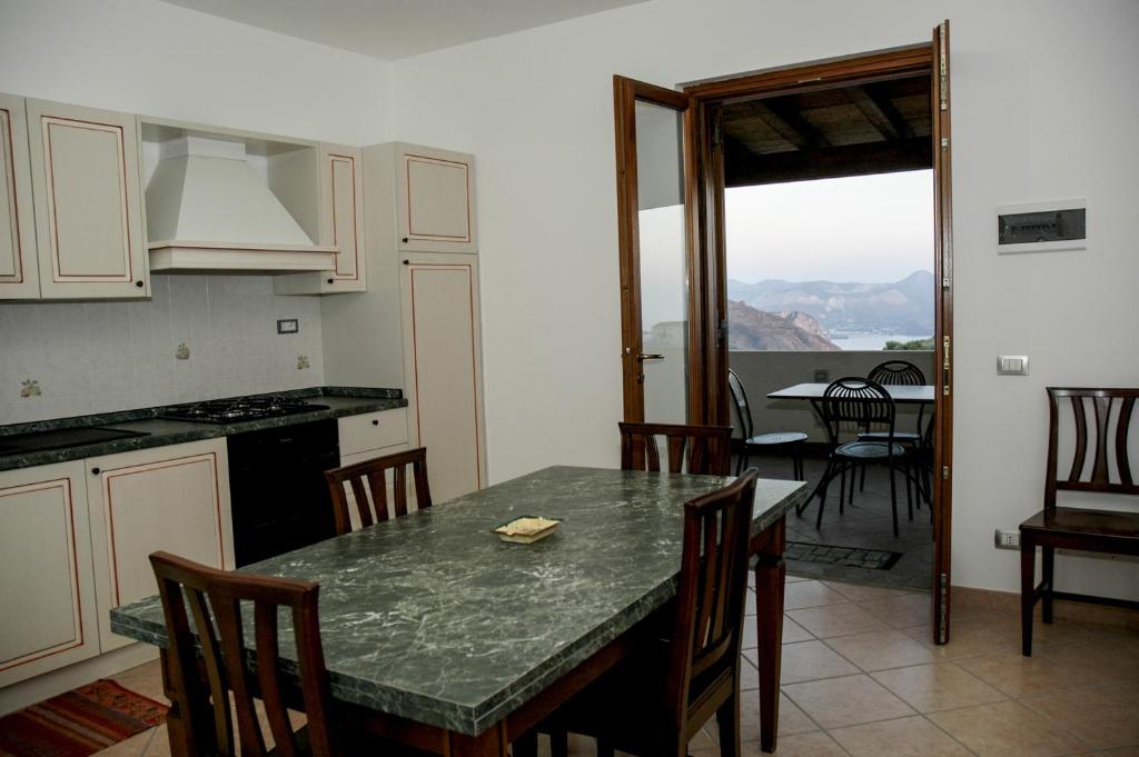 una cucina e una sala da pranzo con tavolo e sedie di Eolian Residence a Città di Lipari