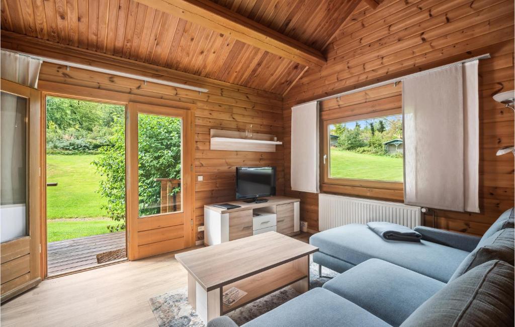 un soggiorno con divano blu e TV di Amazing Home In Oberharz With Kitchen a Waldschlösschen