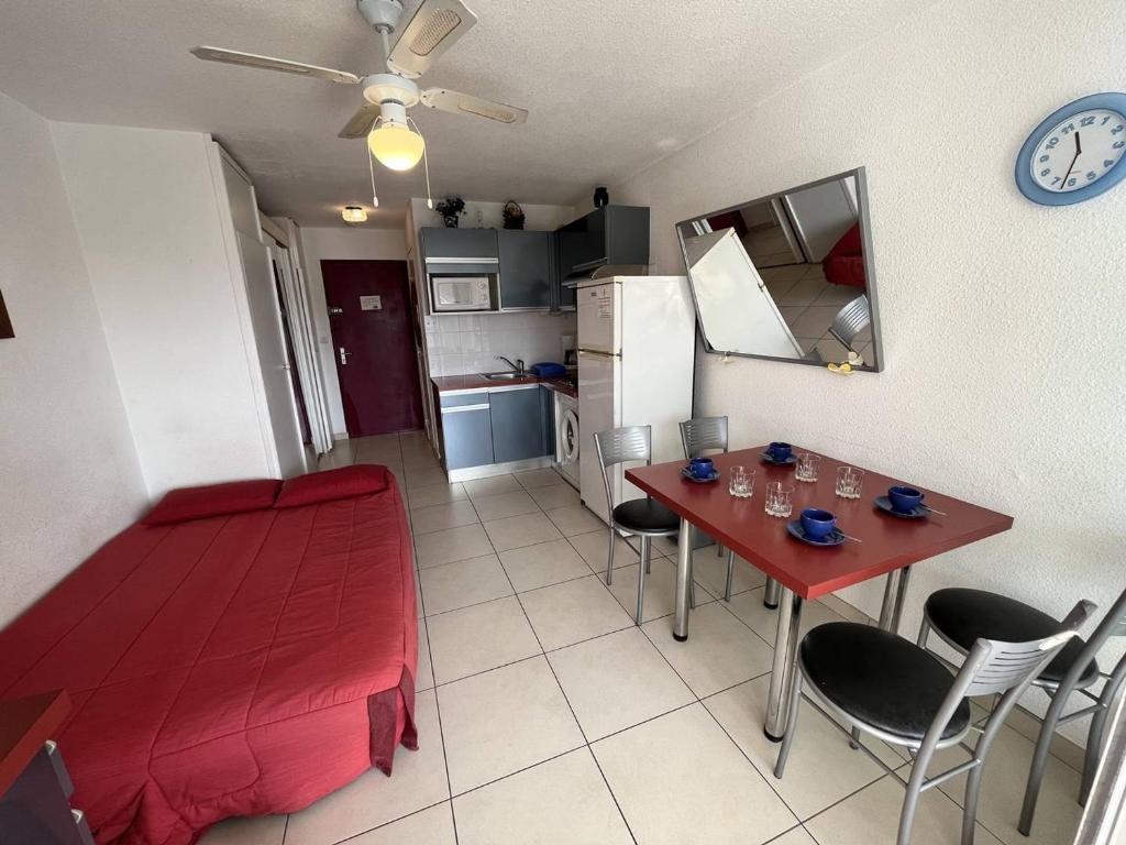 une cuisine et une salle à manger avec une table et des chaises rouges dans l'établissement Studio 2 pers avec terrasse et piscine au Cap d'Agde - FR-1-249A-25, au Cap d'Agde