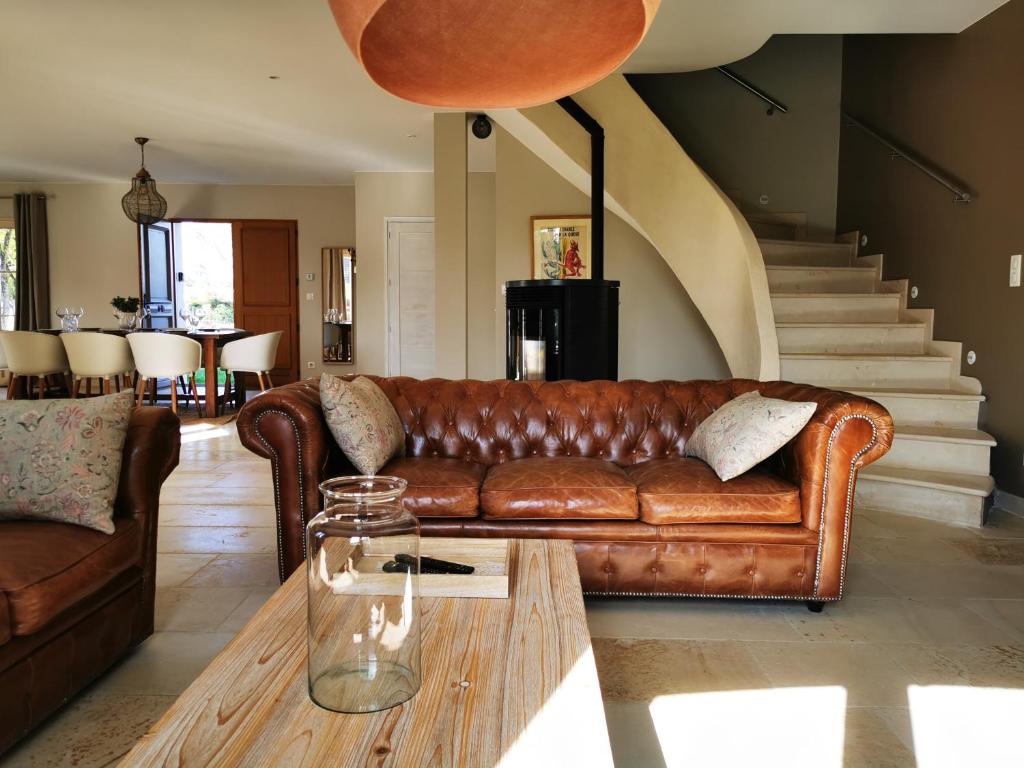 een woonkamer met een leren bank en een salontafel bij La Chouette - Les Bastides d'Edouard - Bourgogne in Mailly-le-Château