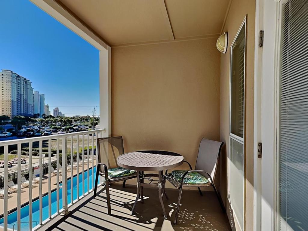 a balcony with a table and chairs and a view of the city at Grand Caribbean #306 West in Perdido Key