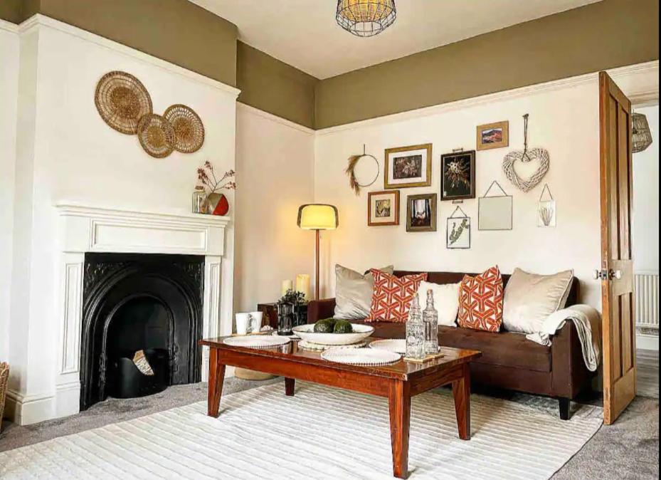 a living room with a couch and a fireplace at Autumn Loft Wyndale Living Malvern Hills - Free Parking in Great Malvern