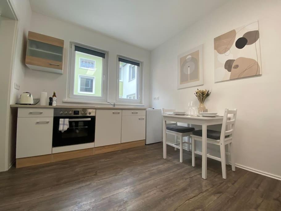 a kitchen with a table and a table and chairs at Modernes Studio, zentral in Würzburg