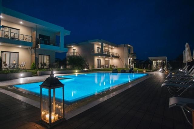 a large swimming pool in front of some buildings at night at Olea Mare in Kalives Poligirou