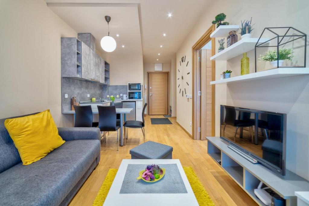 uma sala de estar com um sofá e uma mesa em Luxury Kalman Centar Apartman em Zlatibor