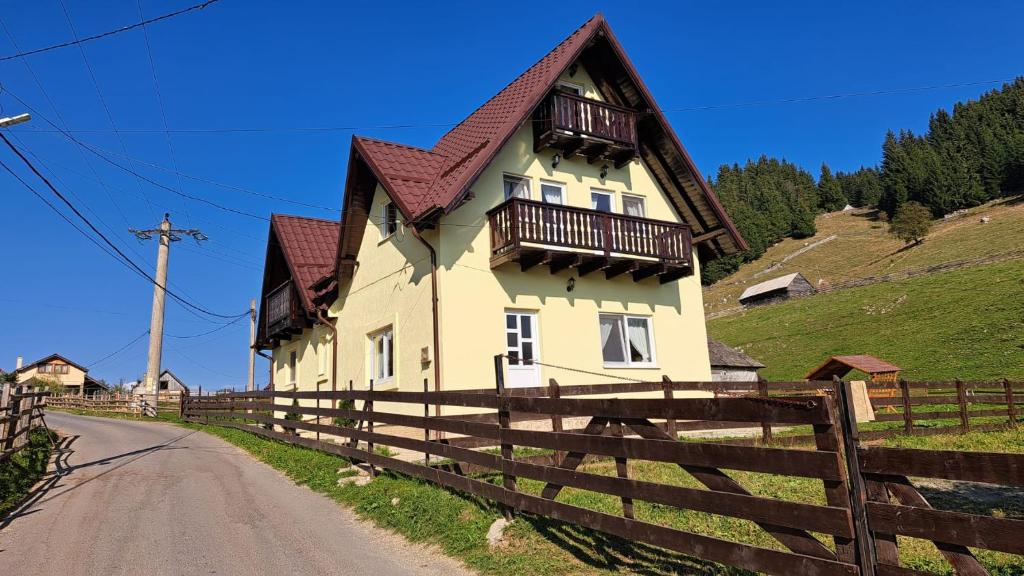 una casa con una recinzione di legno accanto a una strada di Casa Caprioara a Fundata