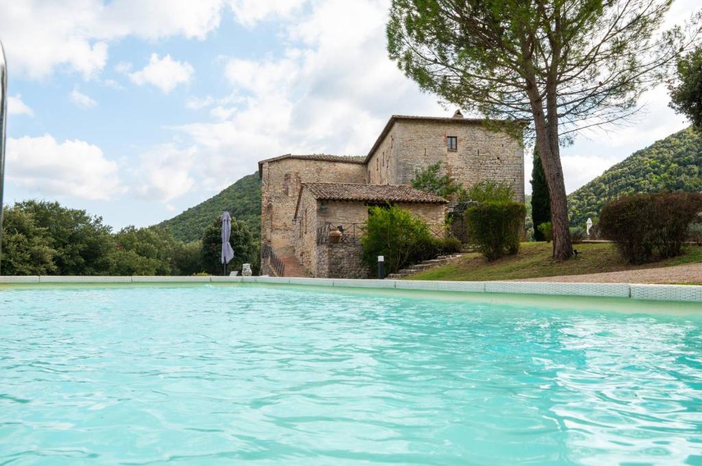 a large swimming pool in front of a building at Castello Valenzino in Umbertide