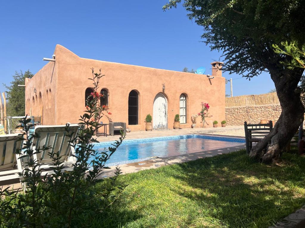 Belle villa Baldi à la campagne d'Essaouira في الصويرة: منزل به مسبح امام مبنى