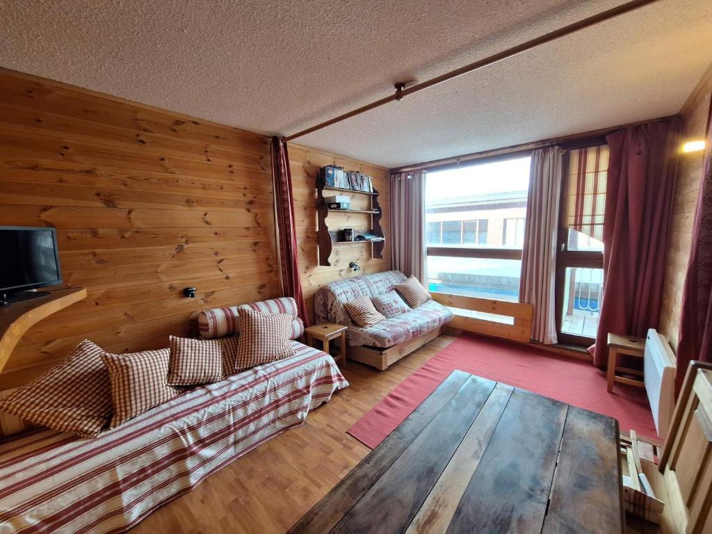 ein Wohnzimmer mit einem Sofa und einem TV in der Unterkunft Appartement Les Arcs 1800, 2 pièces, 5 personnes - FR-1-411-31 in Arc 1800