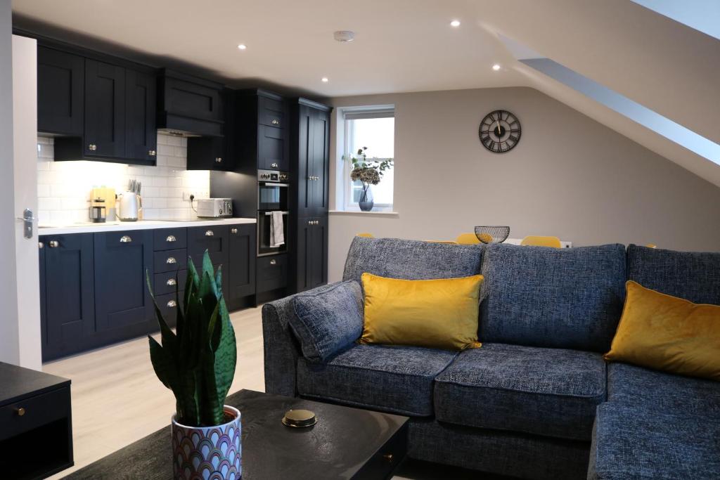 sala de estar con sofá azul y cocina en Church Suites Enniskillen en Enniskillen