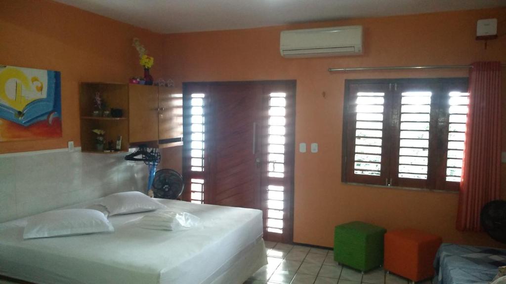 1 dormitorio con 1 cama blanca y 2 ventanas en Solar de Iracema Flat, en Fortaleza