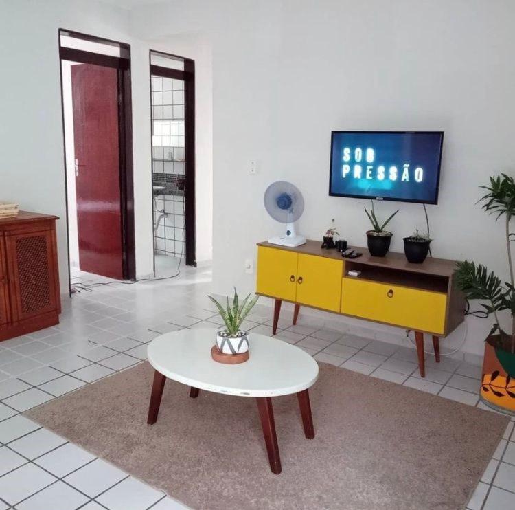sala de estar con TV y mesa en Brisa Praiana lll, en Cabedelo