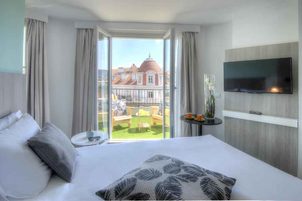 a bedroom with a bed and a large window at Ibis Styles Nice Centre Gare in Nice
