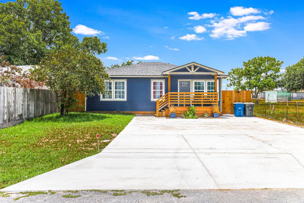 une maison bleue avec une clôture dans une cour dans l'établissement Ideal Time, à Île Padre