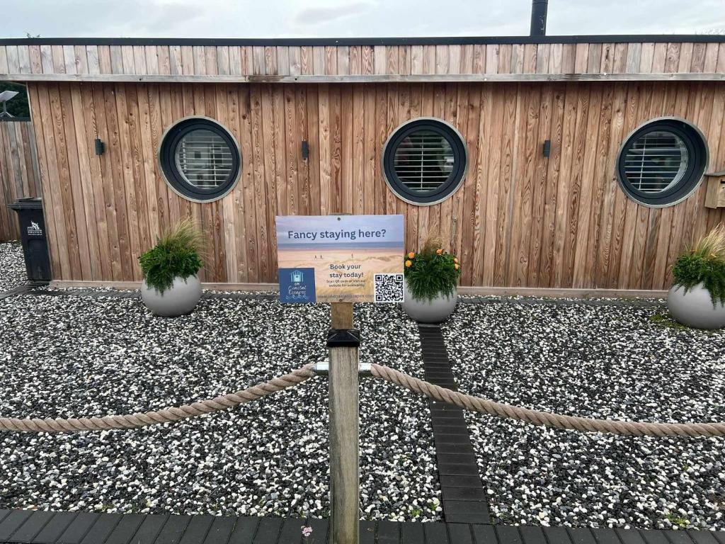 a sign in front of a building with a fence at Humberston Boathouse Lodges with Hot Tub - Cleethorpes Beach Cabin Chalet in Humberston