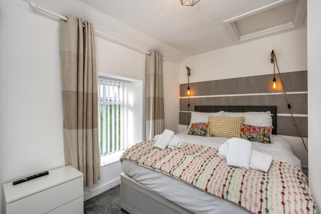 a bedroom with a large bed and a window at The New Lodge - Cottage - Tv in every bedroom! in Pontardawe