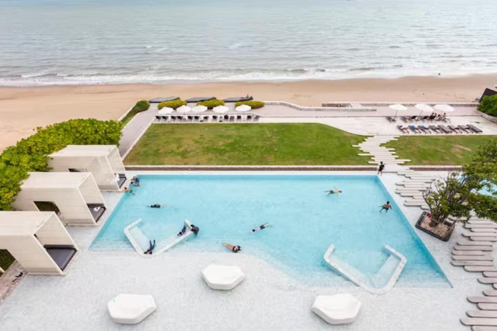 an overhead view of a swimming pool next to the beach at Family Suite Sea view 2Bedroom at Veranda Residence Pattaya in Na Jomtien
