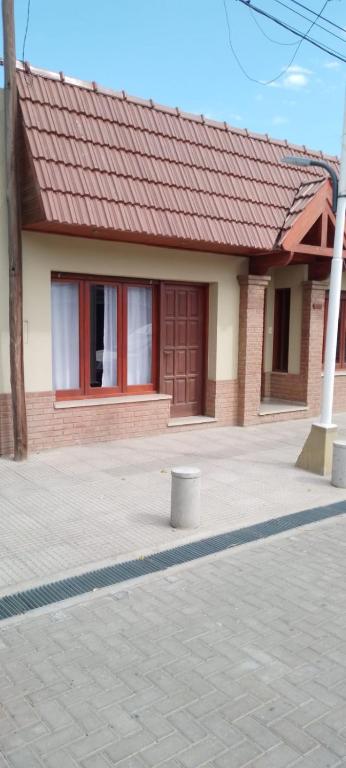a small house with a red roof and a building at Departamento VILLA NUEVA in Villa María