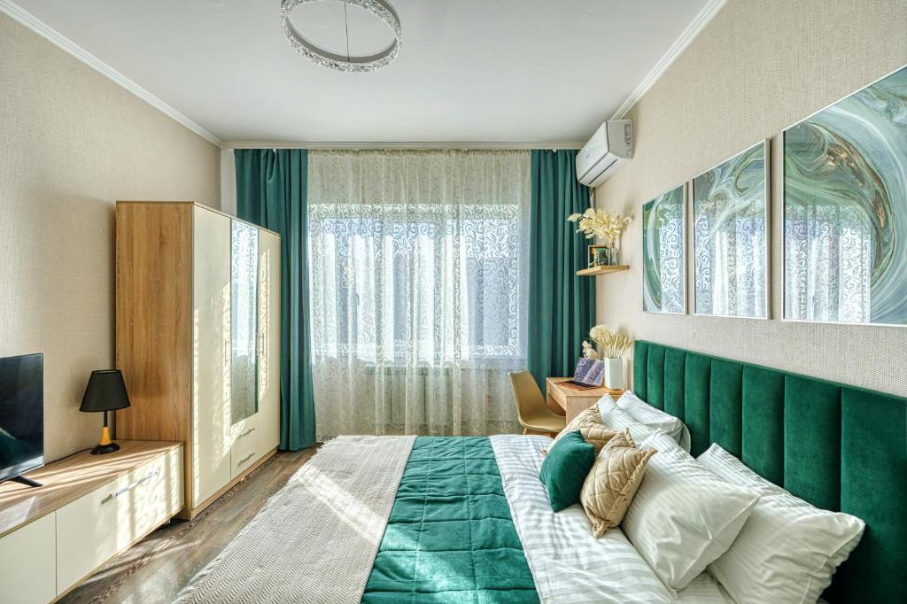 a bedroom with a green headboard and a bed at Green Boutique - квартира в изумрудных оттенках на Мынбаева in Almaty