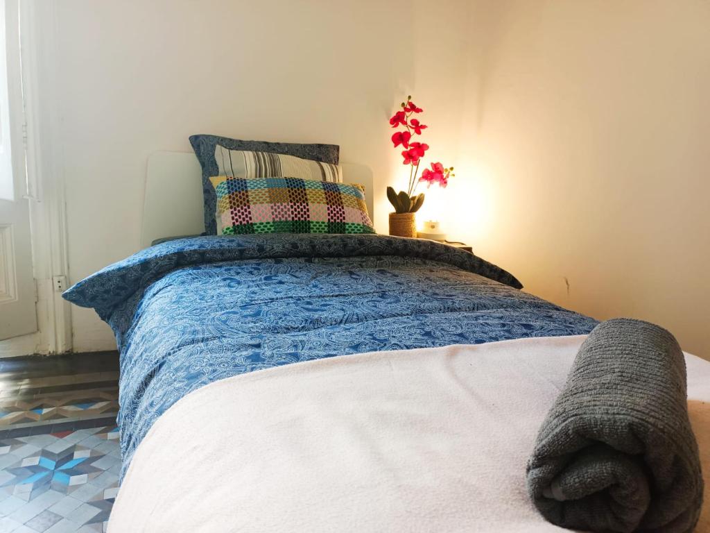 By Urquinaona Rooms في برشلونة: غرفة نوم مع سرير وبطانية زرقاء