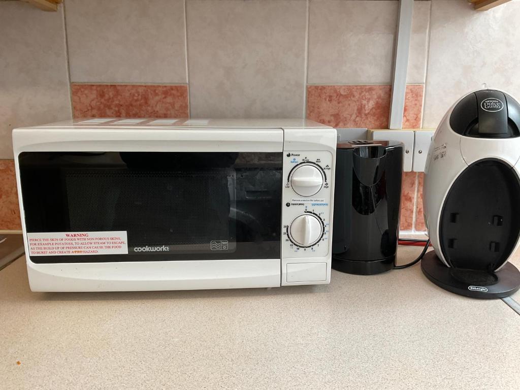 a microwave sitting on a counter next to a blender at 3bed Rooms Apartment Terrace in Crystal Palace