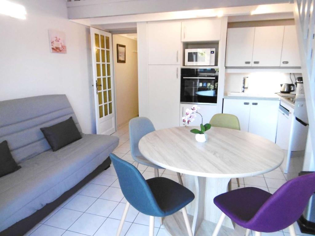 cocina y sala de estar con mesa y sillas. en Studio mezzanine - LAOUEN, en Sarzeau