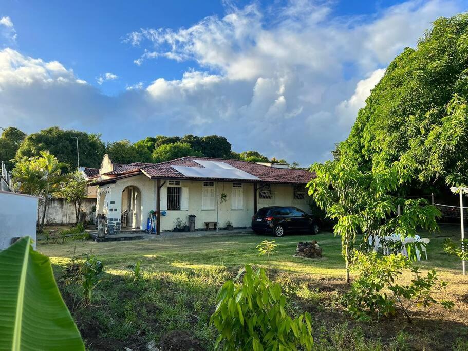 une maison avec une voiture garée devant elle dans l'établissement Chácara Sombra da Mangueira - 150 Mts da Praia, à Itaparica Town