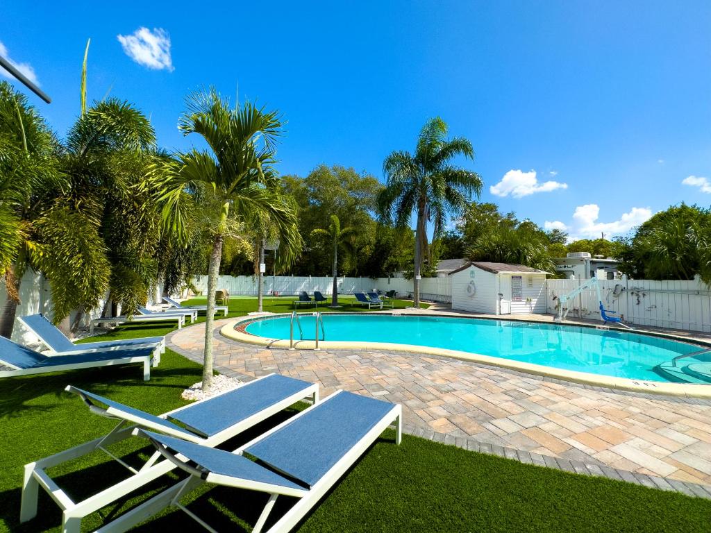 a swimming pool with lounge chairs in a yard at 2q Suite Apt W Shared Pool 10 To Beach 05 in Clearwater