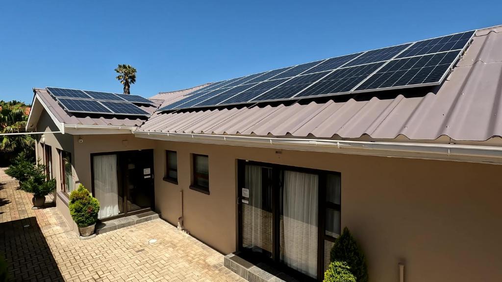a house with solar panels on the roof at MeTime Guesthouse & Self catering in Hartenbos