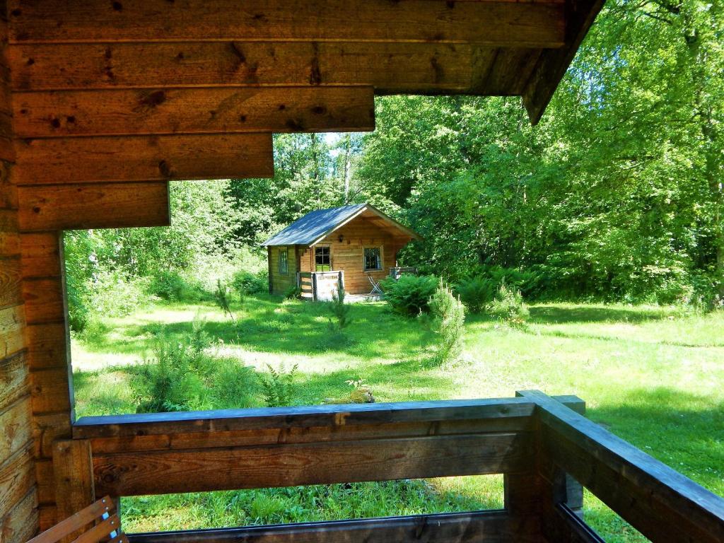a view of a cabin from the porch of a log house at Haaviku Nature Lodge in Sagadi