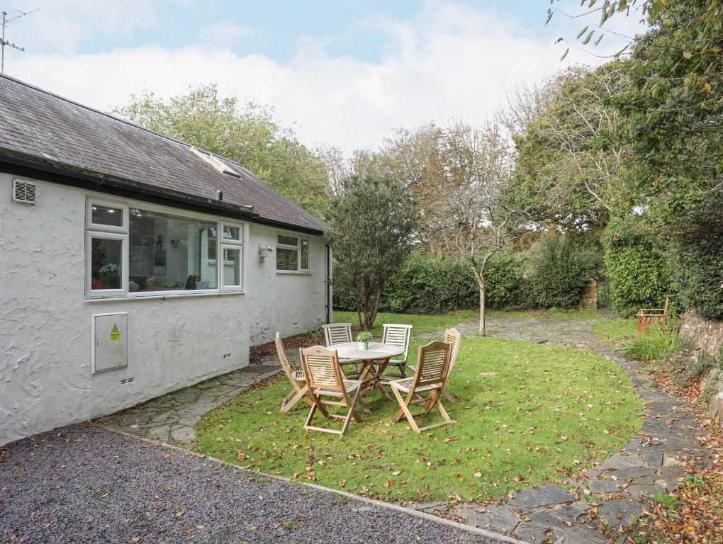 a table and chairs in the backyard of a house at Ty Cerrig in Pwllheli