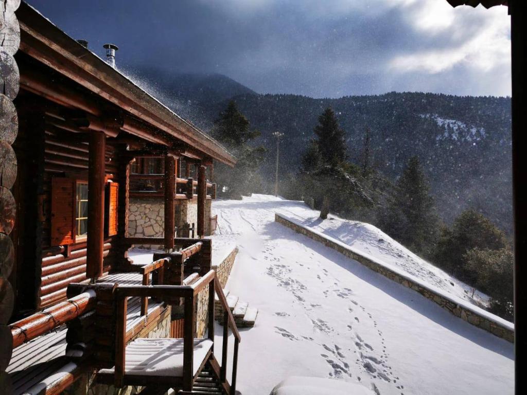 a snow covered porch of a cabin with footprints in the snow at Chalet Aroania in Kalavrita