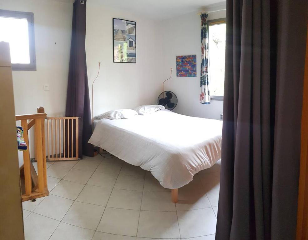 a bedroom with a white bed in a room at Petit Paradis au calme en plein Marseille in Marseille