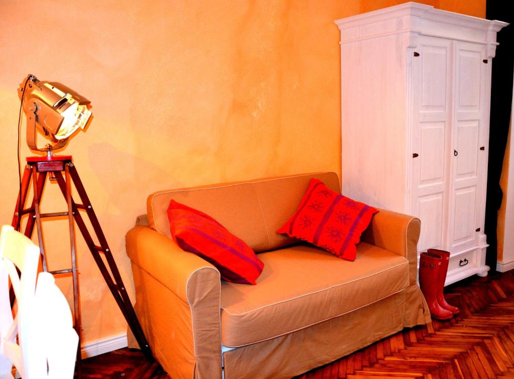 sala de estar con sofá y 2 almohadas rojas en Silver Wolf Wood, en Cracovia