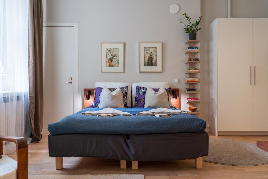 sypialnia z łóżkiem z niebieską pościelą i poduszkami w obiekcie FREDA - Relaxing downtown studio w Helsinkach