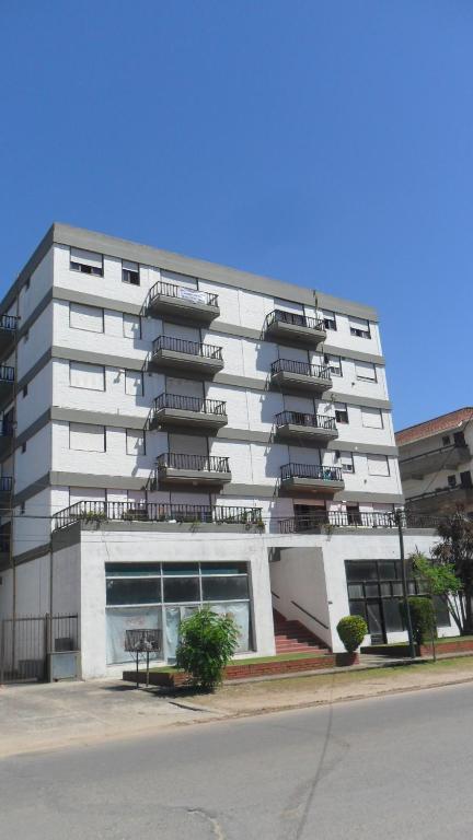 un edificio blanco con balcones en un lateral en DEPTO 2 CON CON COCHERA VILLA GESELL en Villa Gesell