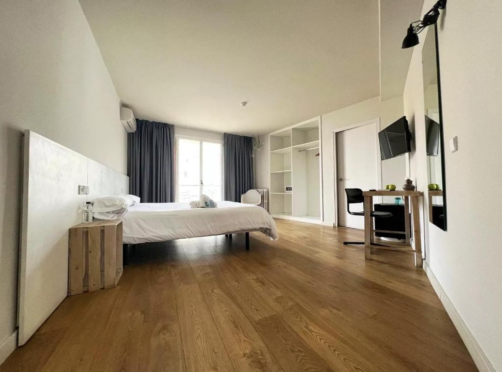 una camera bianca con un letto e una scrivania di Dynamic Hotels Caldetes Barcelona a Caldes d'Estrac