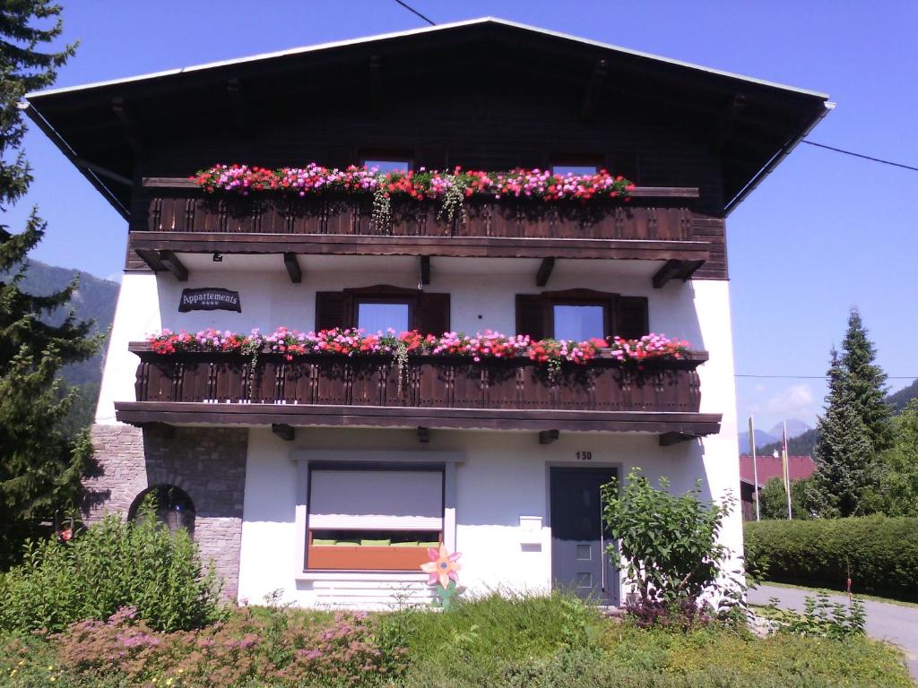 una casa con un balcón con flores. en Appartements Zankl, en Kötschach-Mauthen