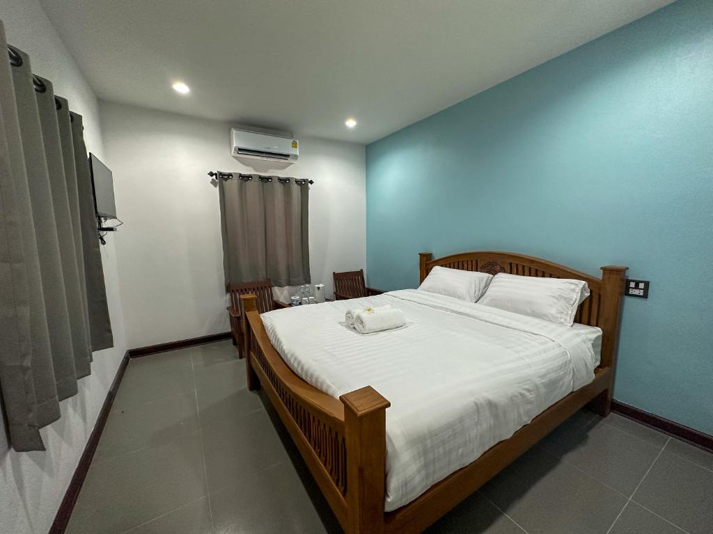 - une chambre avec un grand lit et un mur bleu dans l'établissement บ้านชมฟ้า - Bann Chomfah Resort & Cafe, 